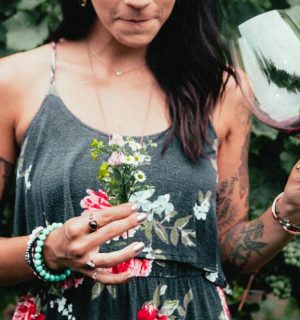 womens-fashion-tattooed-woman-holding-flowers-and-wine.jpg